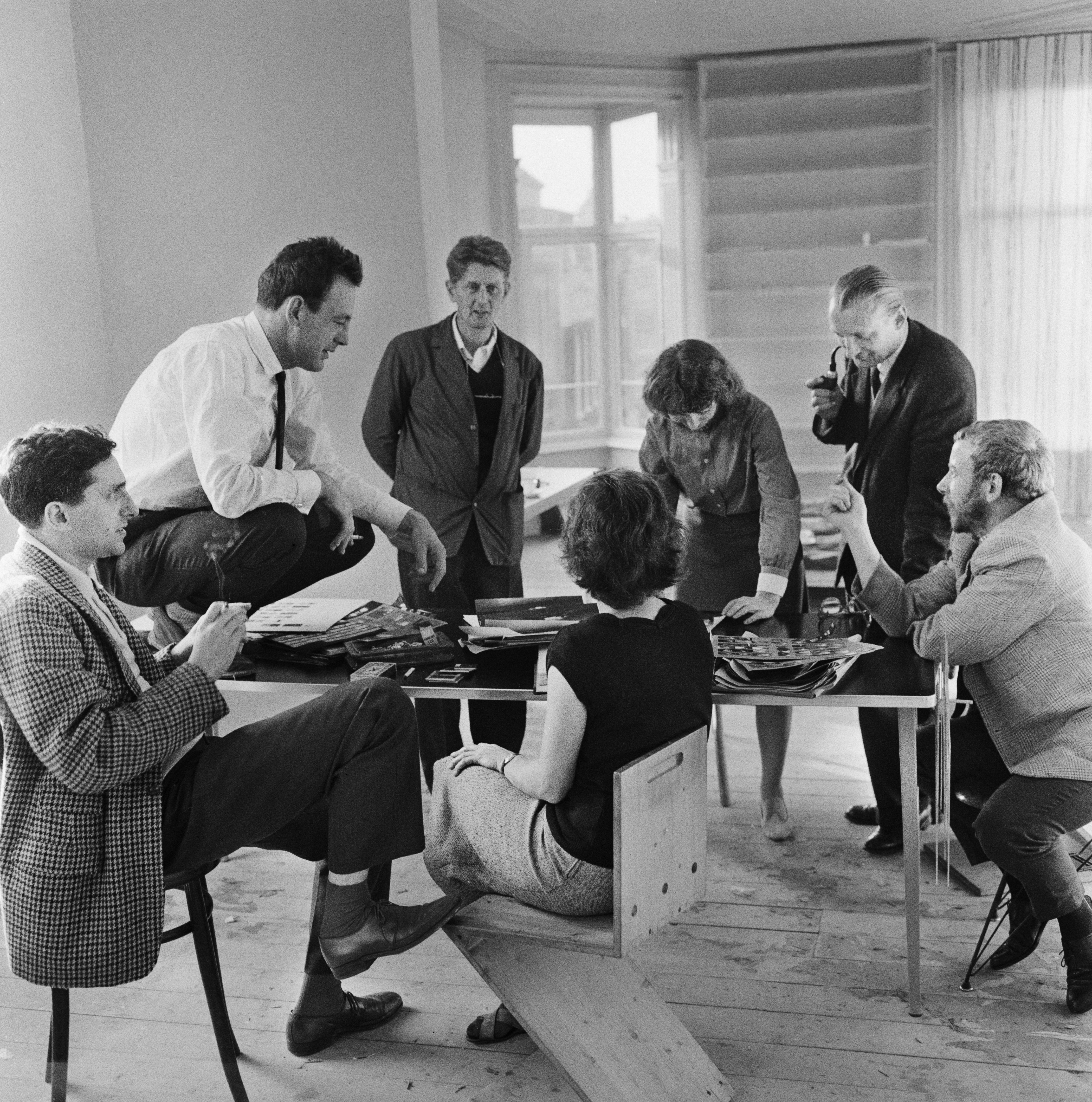 Editorial meeting for the photobook Vuur aan zee at Violette Cornelius’s home, Spuistraat, Amsterdam, 1958. From left to right: Paul Huf, Jurriaan Schrofer, Cas Oorthuys, Violette Cornelius, Ata Kandó, Paul Rodenko and Ed van der Elsken © Violette Cornelius / Nederlands Fotomuseum
