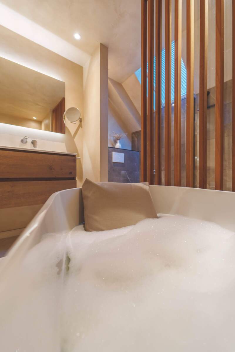 Ultiem genieten in je badkamer, warm sfeervol en met houten accenten gecombineerd 